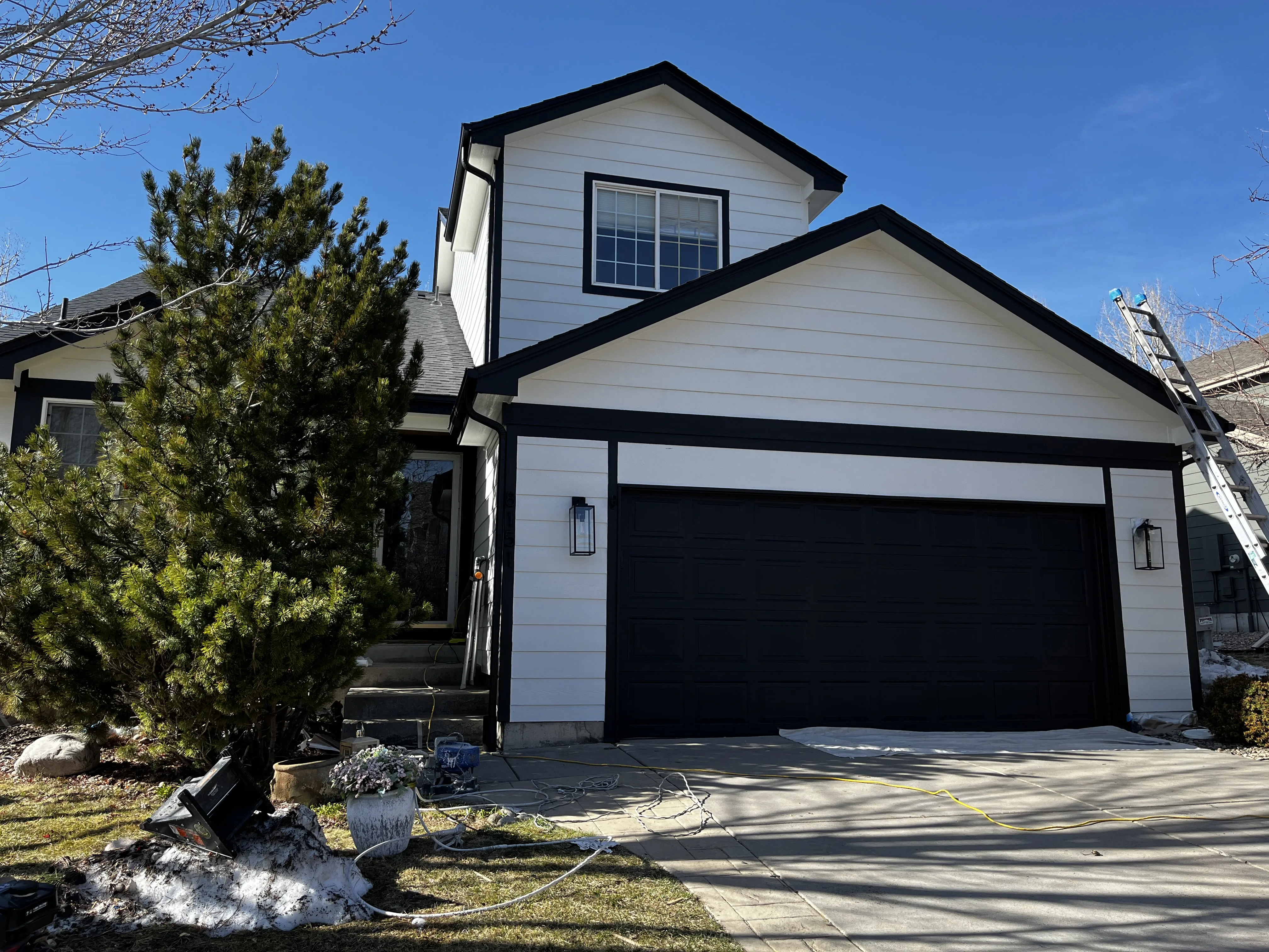 Full exterior repaint — white home with black garage door in Castle Rock