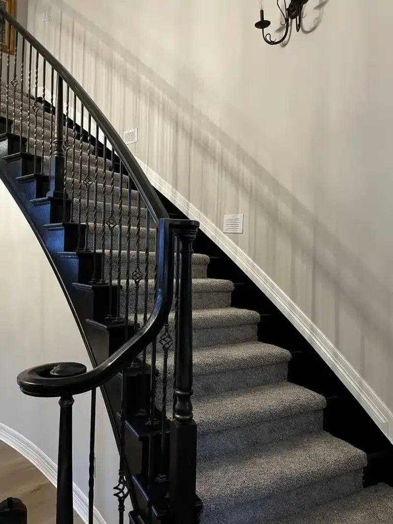 Interior staircase with black iron railing and painted walls
