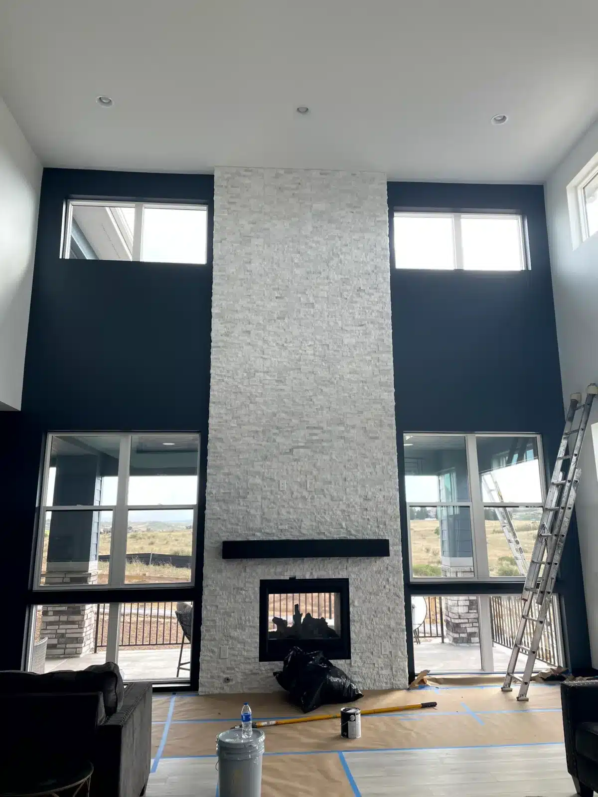 Interior painting with a vaulted ceiling and stone fireplace in Colorado
