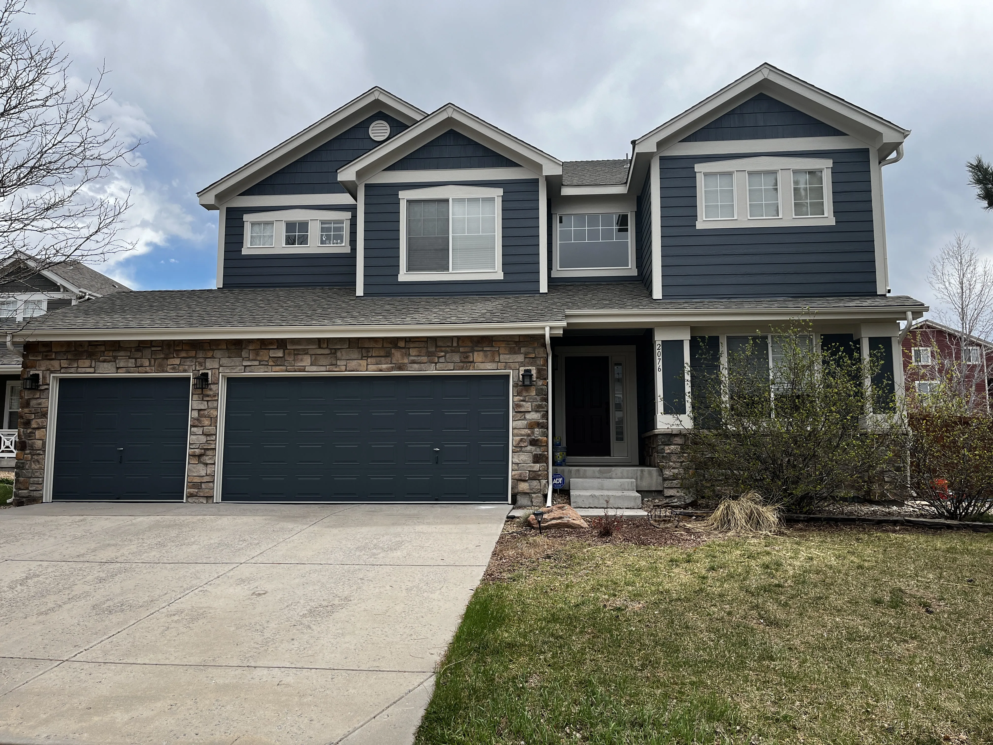 Repainted navy two-storey home with stone accents in the Southern Denver Metro
