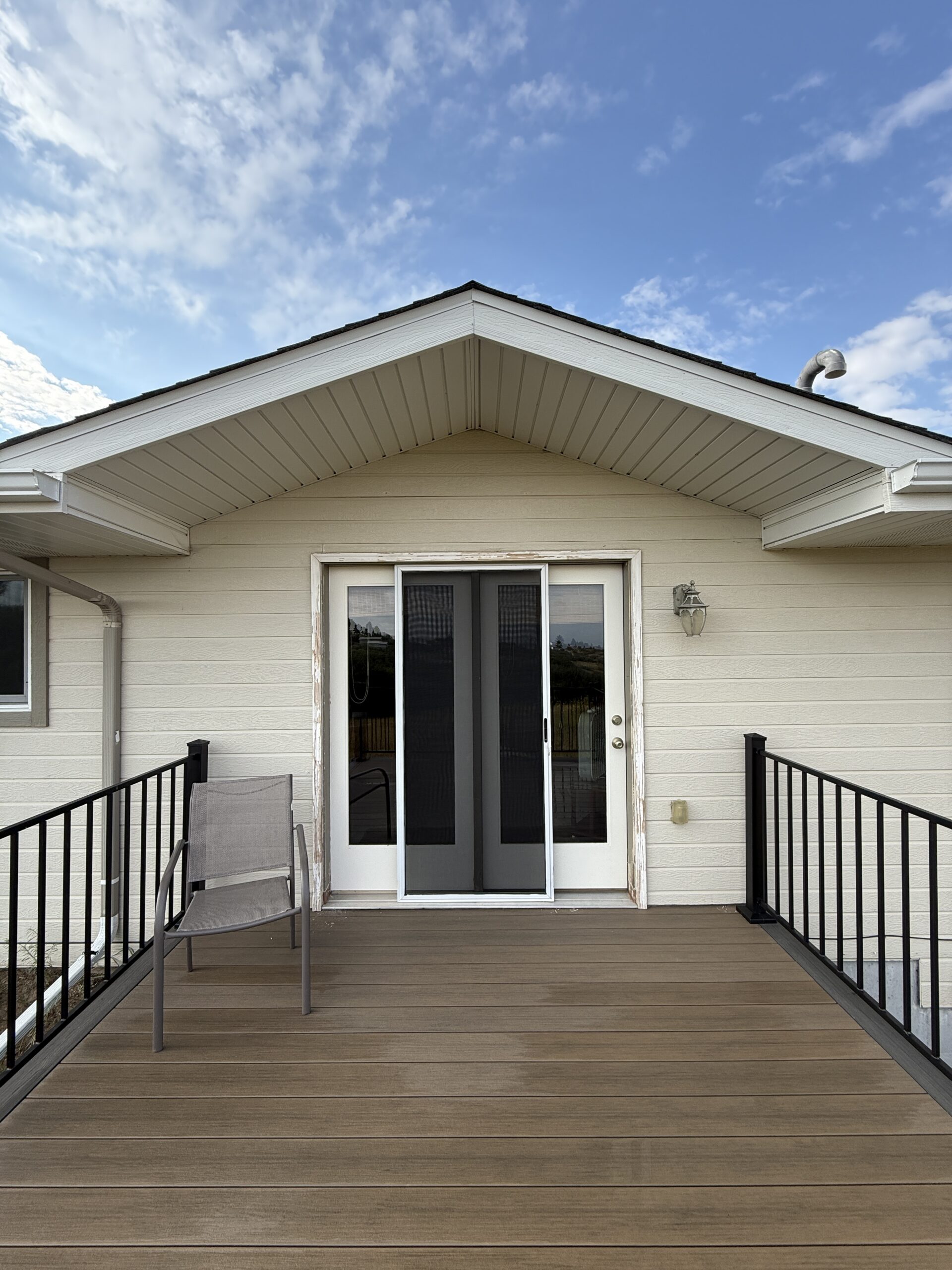 Deck staining in the Southern Denver Metro — rear deck with french doors and black railing