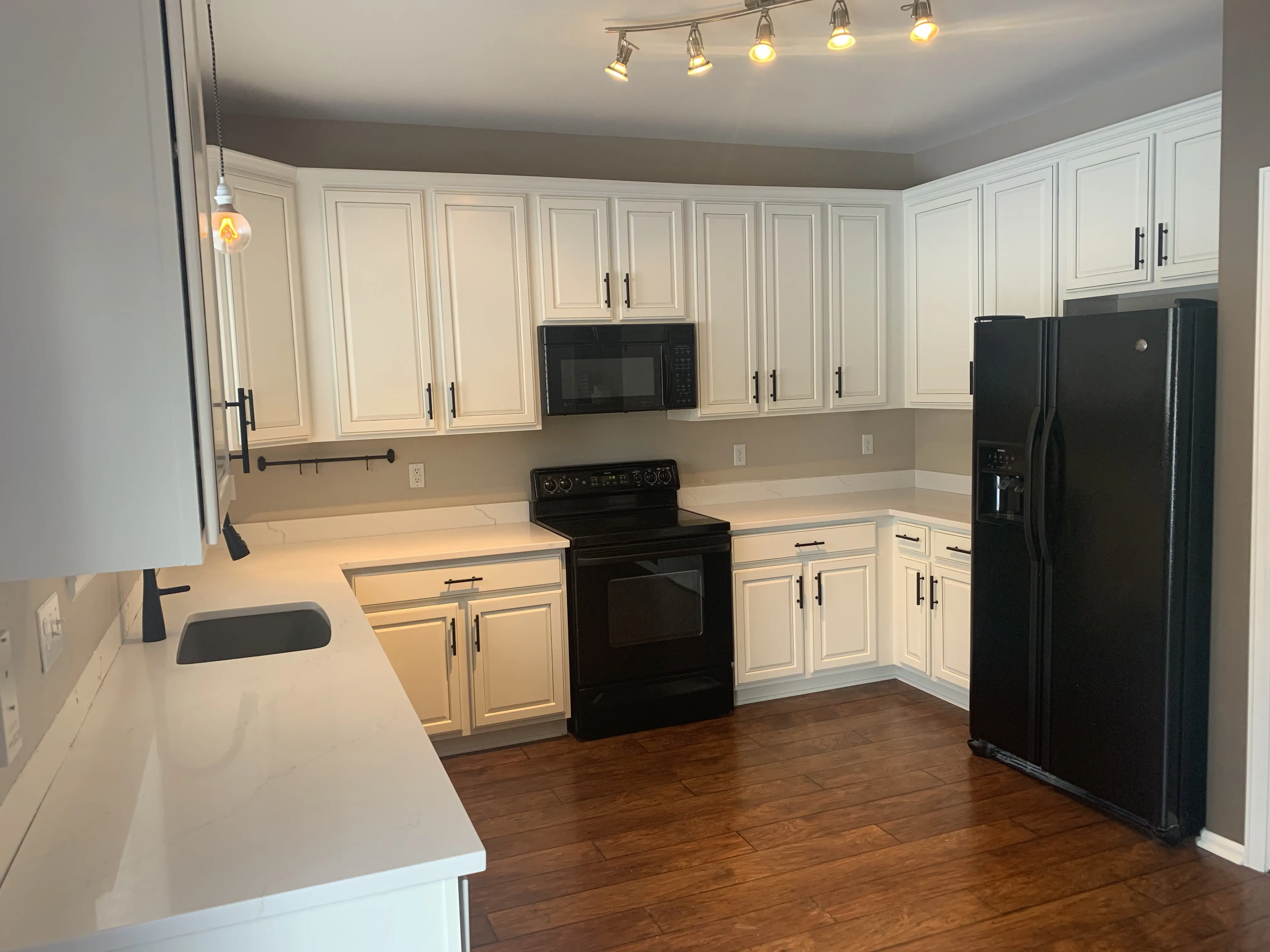Cabinet painting in Castle Rock — white kitchen cabinets with black appliances